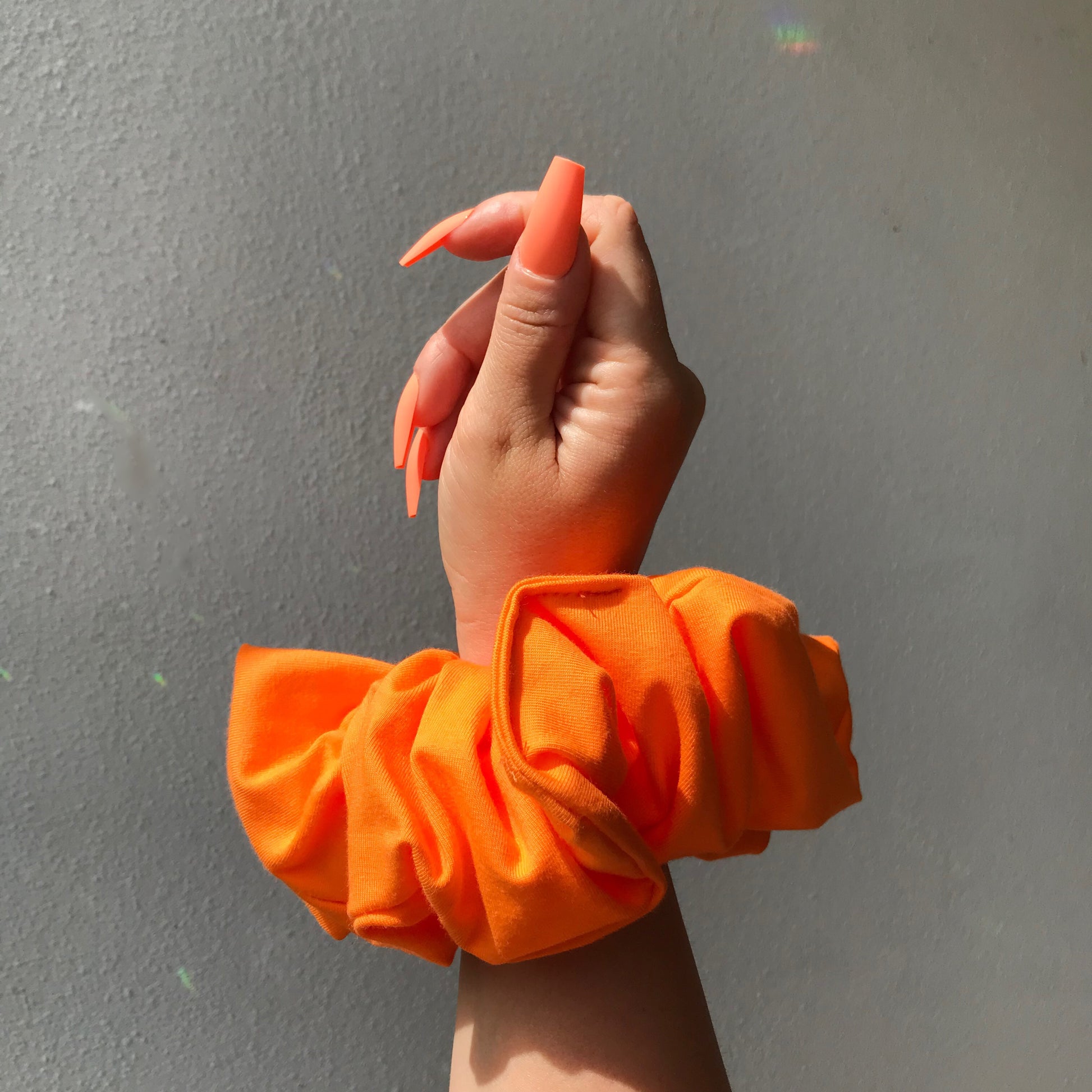 over sized neon orange scrunchie and neon orange nails